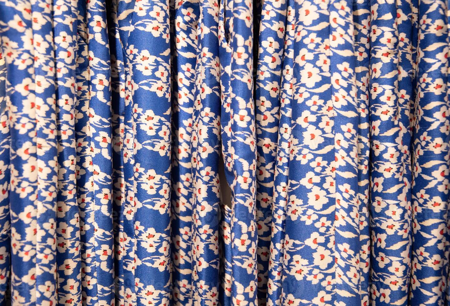 Blau mit rot Blumen Sommer- Blusen auf ein Aufhänger im das speichern, hell Kleider foto
