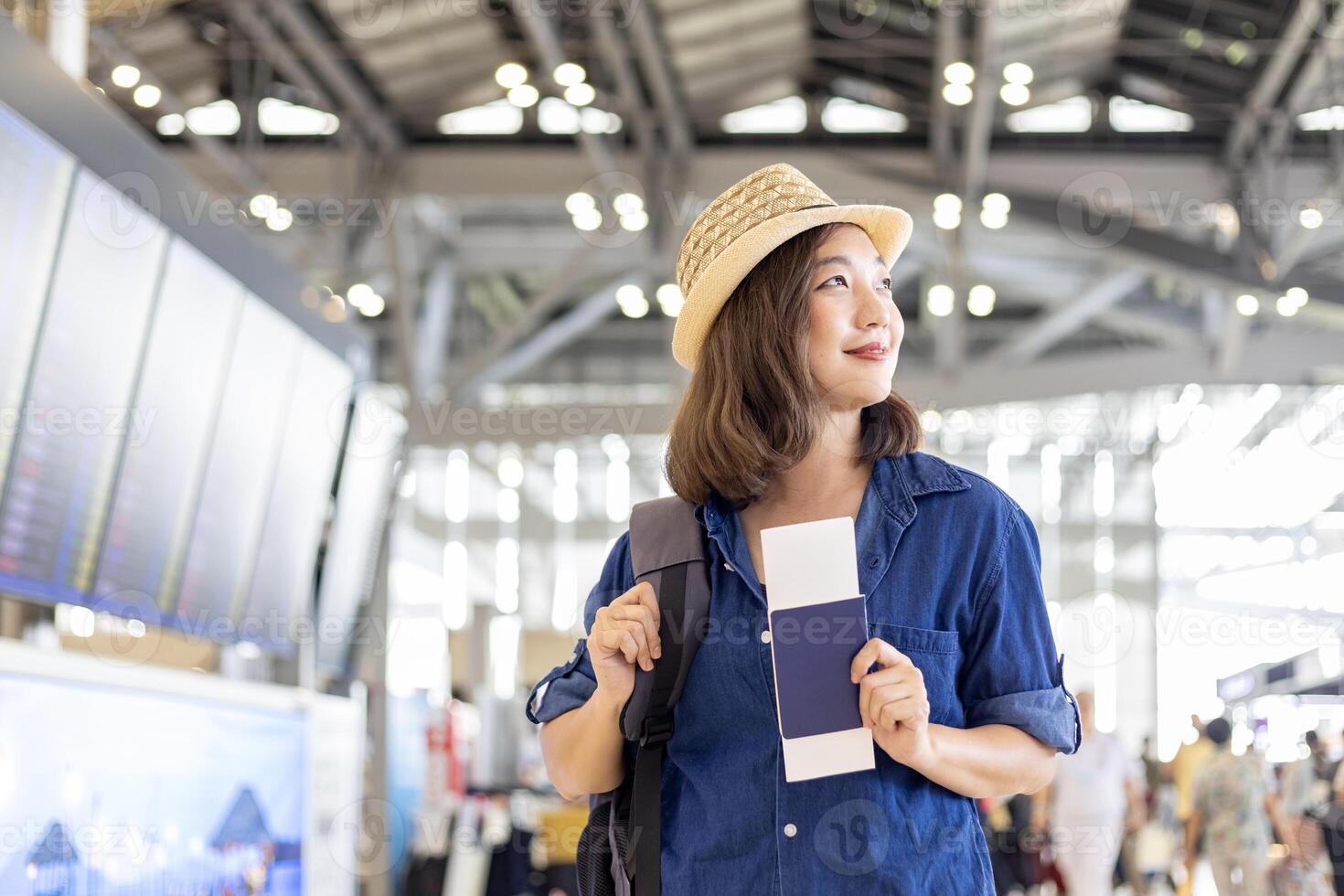 jung asiatisch Frau Passagier mit ihr tragen auf Gepäck ist suchen beim ihr Einsteigen bestehen nach selbst prüfen Kiosk im beim Flughafen Terminal zum International Reise Flug und Ferien foto