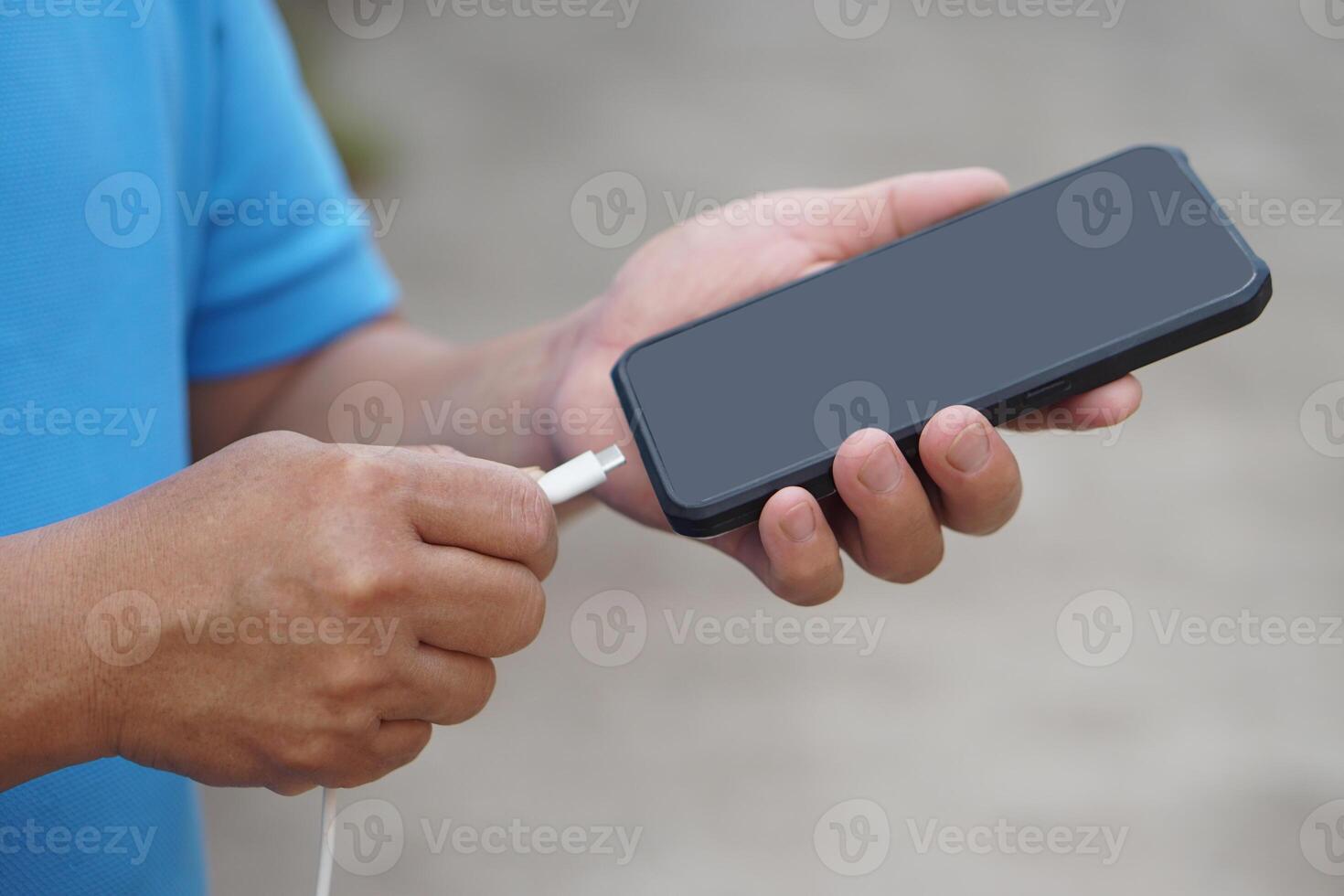 schließen oben Mann Hand verwenden USB Kabel zu verbinden mit Smartphone. Konzept, Technologie Gerät zum verbinden, aufladen oder Transfer Daten zu Smartphone im Täglich Leben. foto