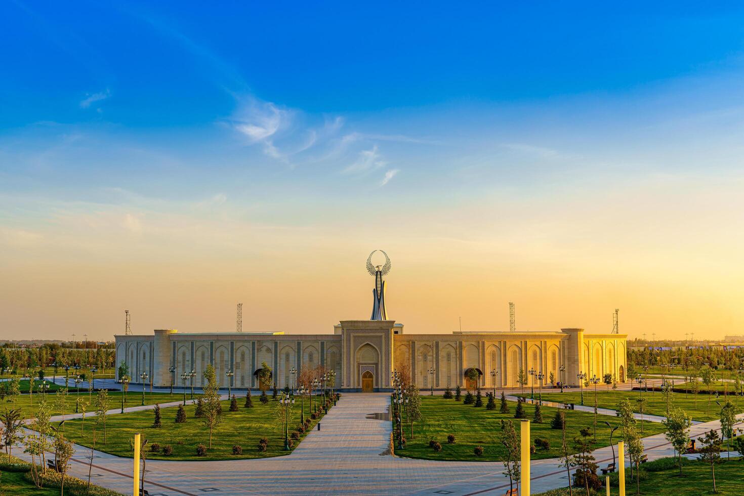 Usbekistan, Taschkent - - April 25, 2023 das Gebiet von das Park Neu Usbekistan mit Monument von Unabhängigkeit im das bilden von ein Stele mit ein Humo Vogel beim Dämmerung. foto