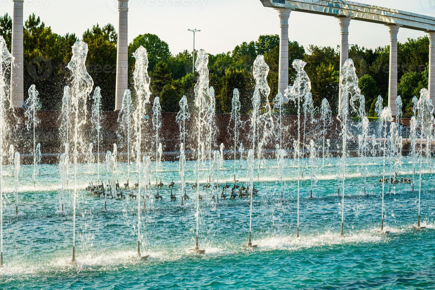 Brunnen beleuchtet durch Sonnenlicht beim Sonnenuntergang oder Sonnenaufgang im das Park beim Sommer. foto