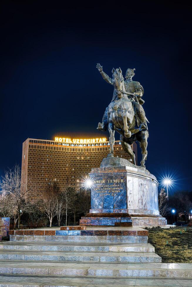 Taschkent, Usbekistan - - März 14, 2023 Monument ami timur oder Tamerlane beim Nachtzeit gegen das Hintergrund von das Hotel Usbekistan. foto