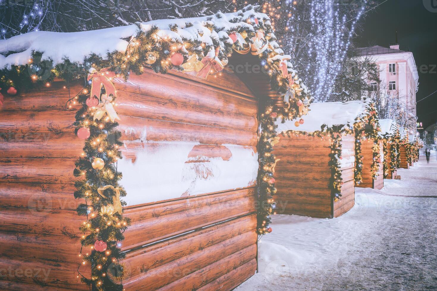 Weihnachten oder Neu Jahre Markt im ein Europa mit Häuser dekoriert mit Spielzeug Bälle und Girlanden beim Nacht. Jahrgang Film ästhetisch. foto