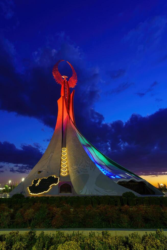 Usbekistan, Taschkent - - Oktober 4, 2023 beleuchtet Monument von Unabhängigkeit im das bilden von ein Stele mit ein Humo Vogel im das Neu Usbekistan Park beim Nachtzeit im Herbst. foto