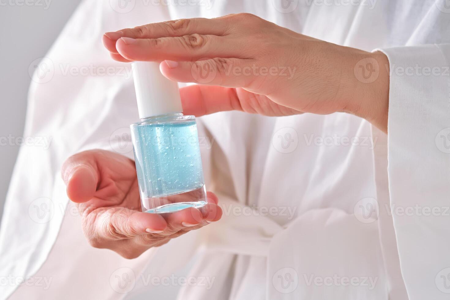 Blau Serum mit Pipette im ein Frauen Hände im ein Kleid. foto