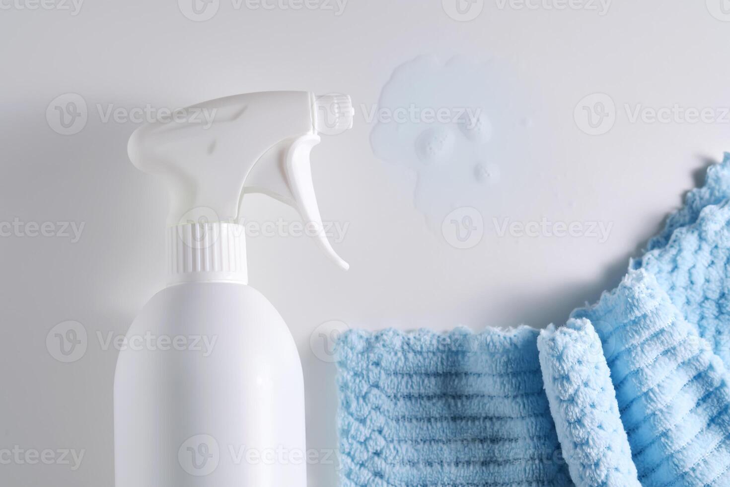 Reinigung Produkt mit ein Sprühgerät auf ein Hintergrund von ein Blau Mikrofaser Tuch. foto