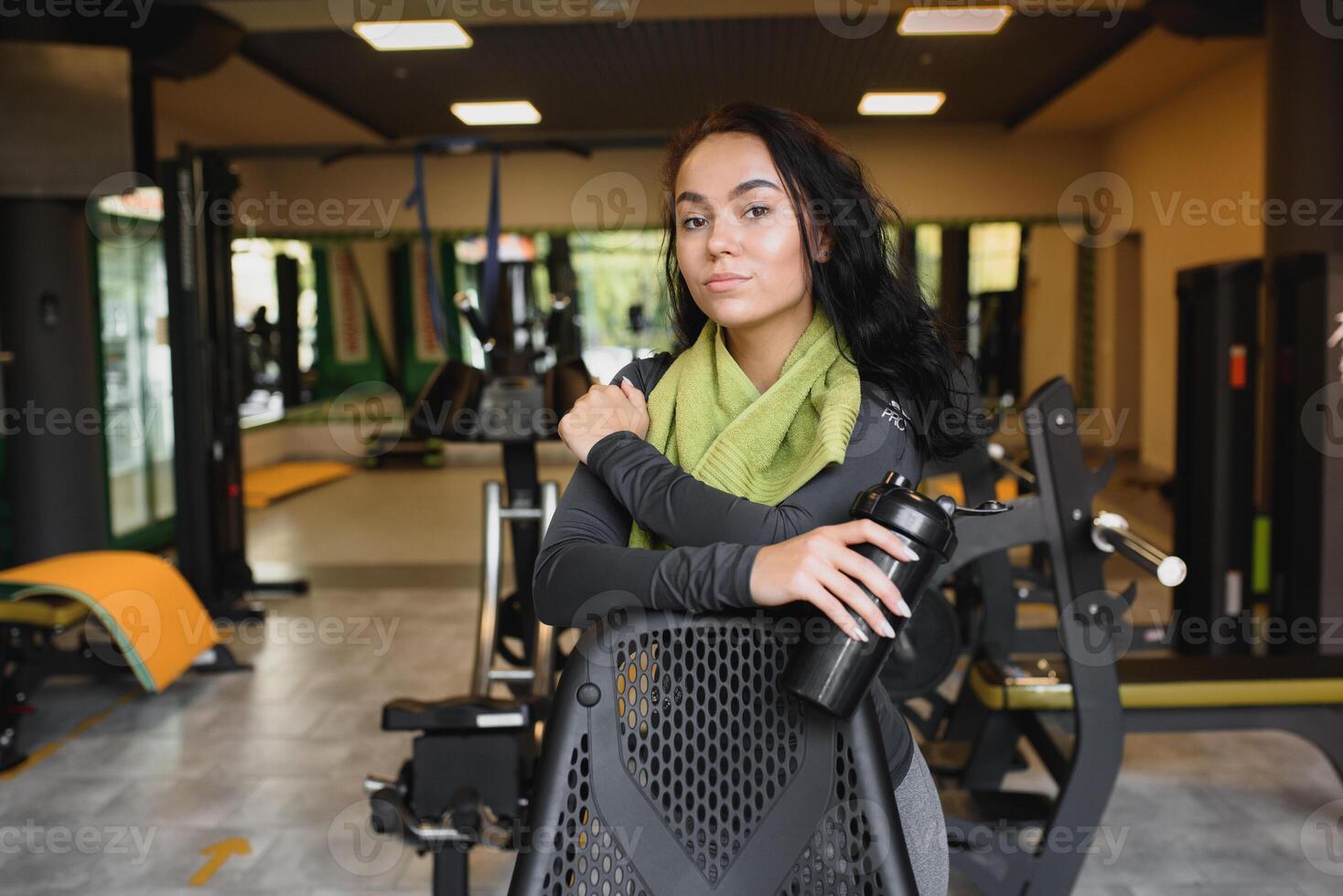 jung Frau Trinken Wasser und nehmen ein brechen nach trainieren im Fitnessstudio foto