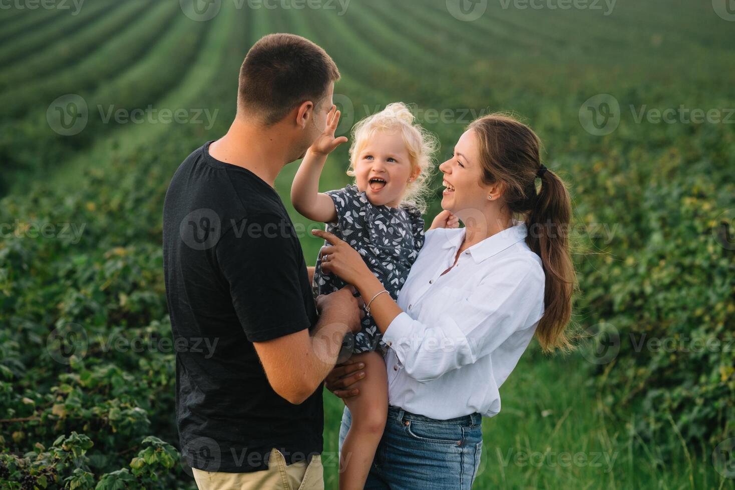 glücklich Familie mit wenig Tochter Ausgaben Zeit zusammen im sonnig Feld. foto