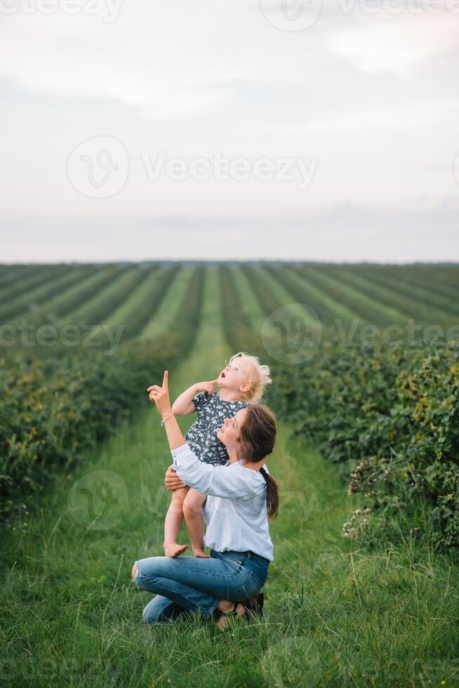 stilvoll Mutter und Tochter haben Spaß auf das Natur. glücklich Familie Konzept. Schönheit Natur Szene mit Familie draussen Lebensstil. glücklich Familie ruhen zusammen. Glück im Familie Leben. Mütter Tag foto