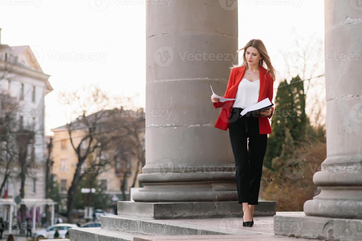 Porträt von Geschäft Frauen im Gefühl von konzentrieren Stress und sehen Stand und halt das Papier Datei Blatt im das draussen Fußgänger gehen Weg mit das Stadt Raum von Außen modern Fassade Gebäude. foto