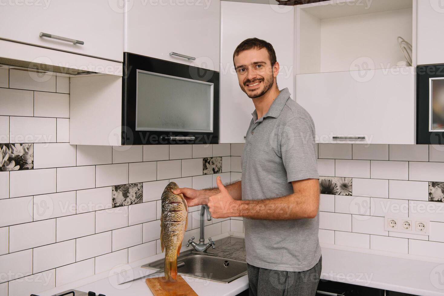 Mann Schneiden frisch Fisch im Küche im heim. Mann schlachten Fisch zum kochen. foto