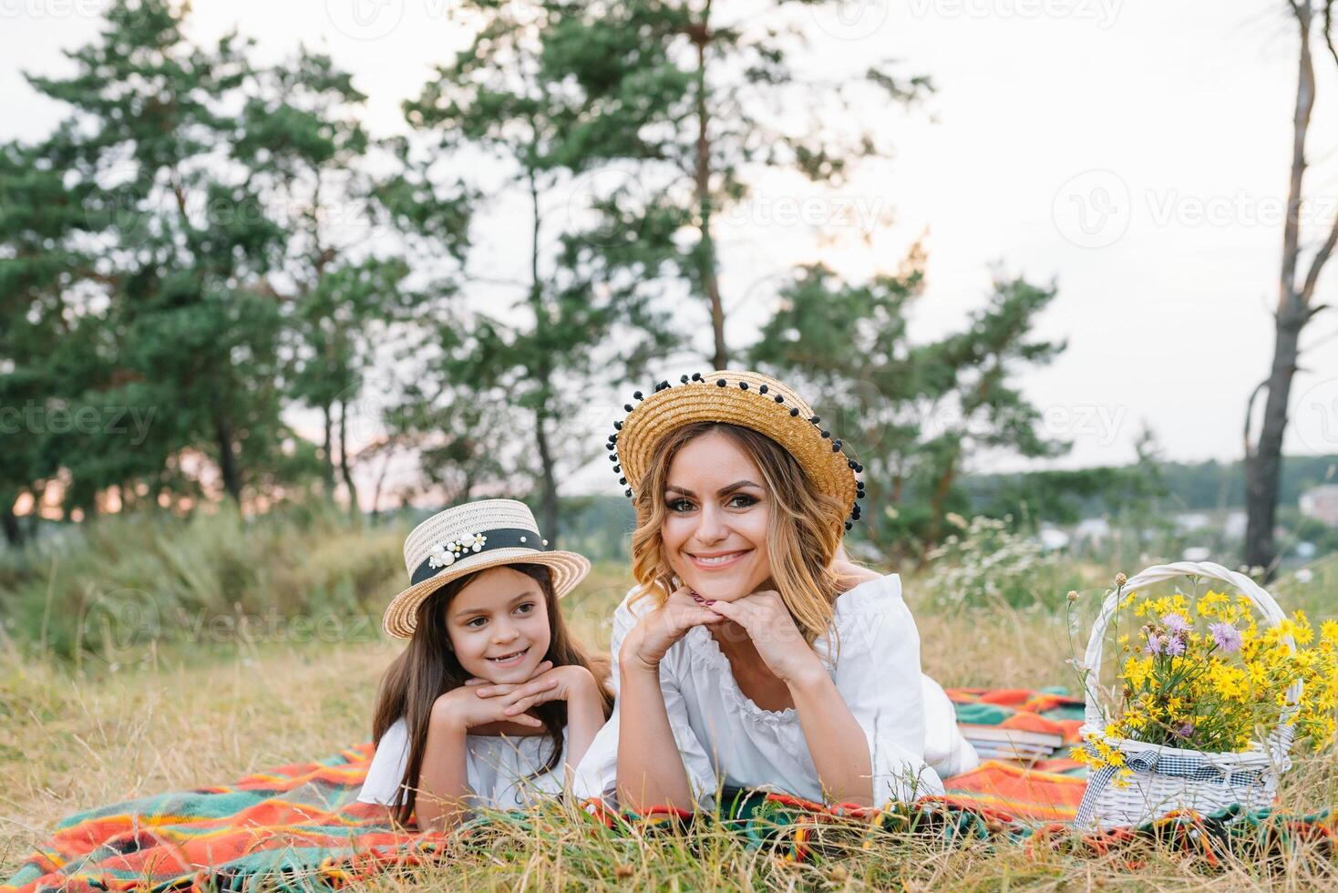 glücklich Frau lächelnd und spielen mit ihr süß wenig Kind, Lügen Outdoor.liebend Mutter und Tochter verbringen Zeit zusammen im ein Park. Mama und Kind hat Spaß. Mutter Tag foto