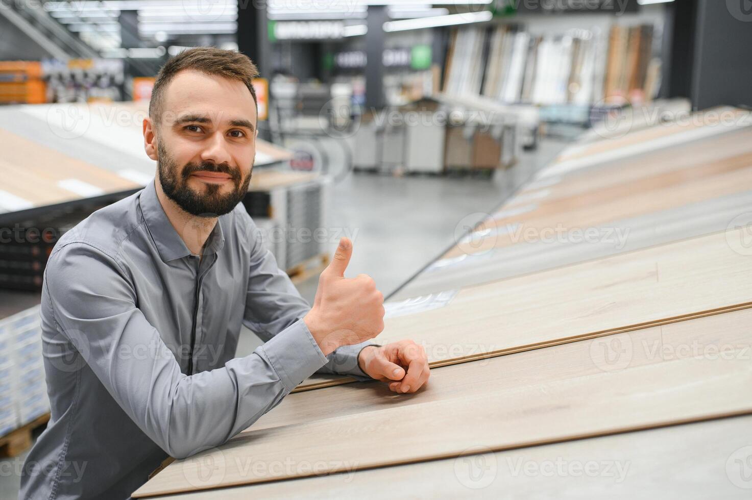 ein jung Mann wählt laminieren Bodenbelag im das Hardware- Geschäft foto