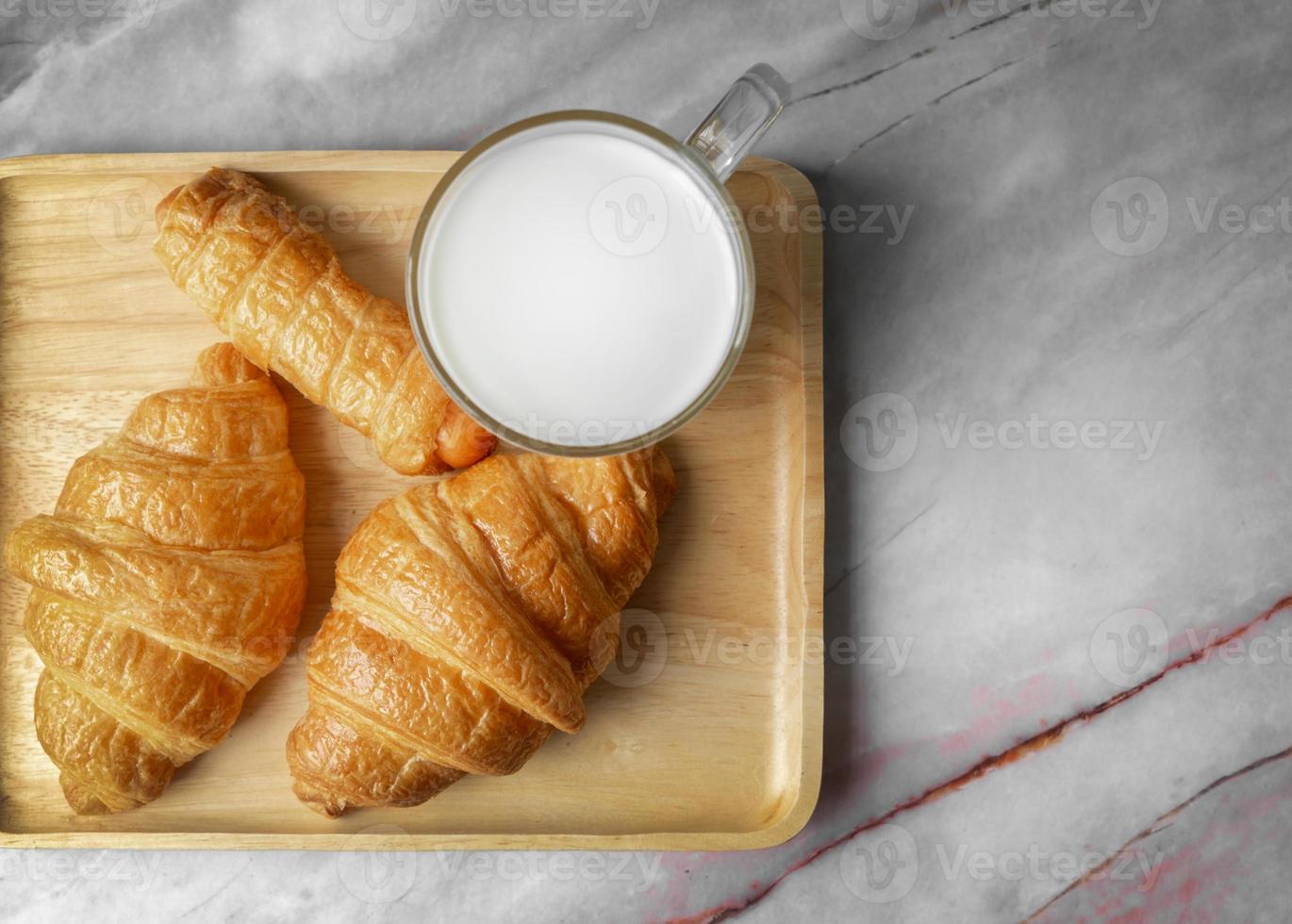 Croissants und Milch von oben auf Marmorhintergrund. foto