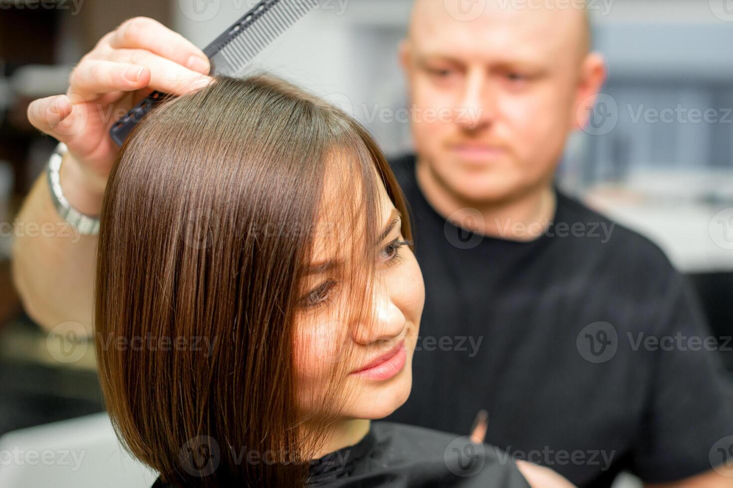 jung kaukasisch Brünette Frau haben ihr Haar Styling durch ein männlich Friseur beim ein Salon. foto