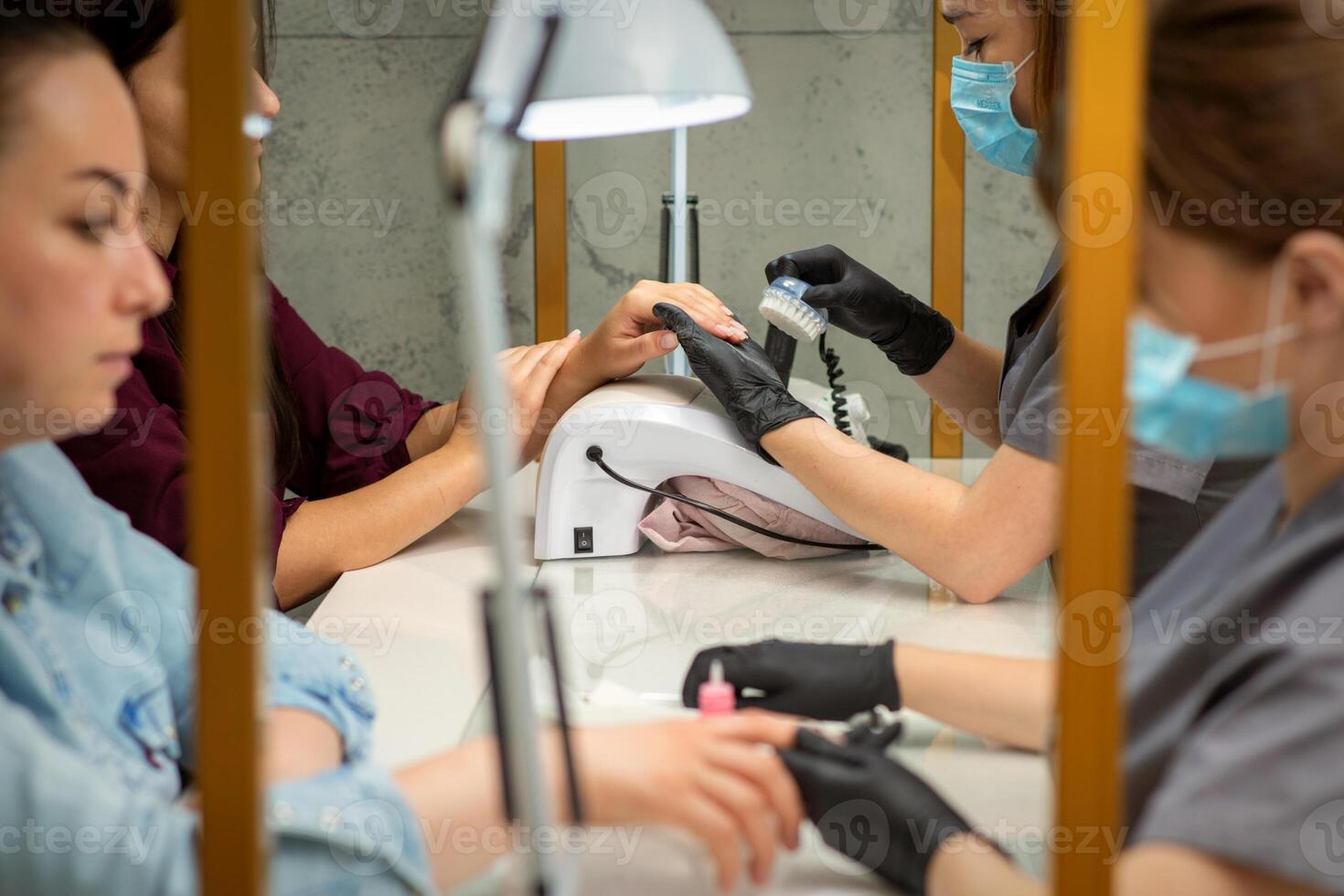 zwei Frauen bekommen ein Maniküre Behandlung im Schönheit Salon. foto