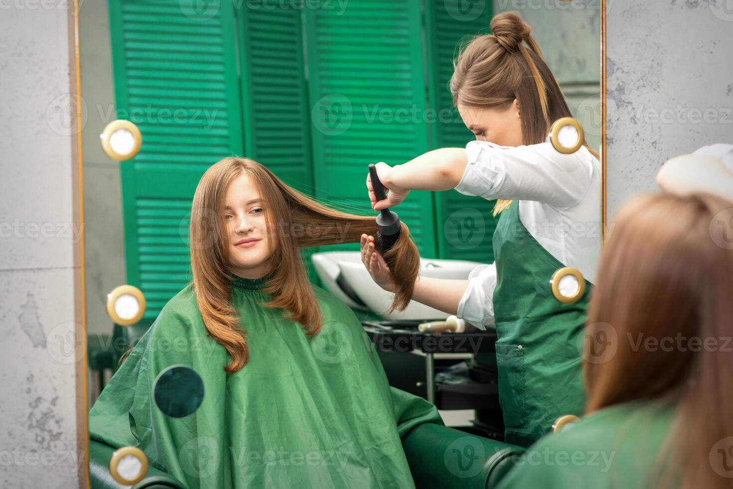 Friseur Herstellung Haar Styling zum das Frau während Kämmen mit Haarbürste, Kamm im ein Haar Salon. foto