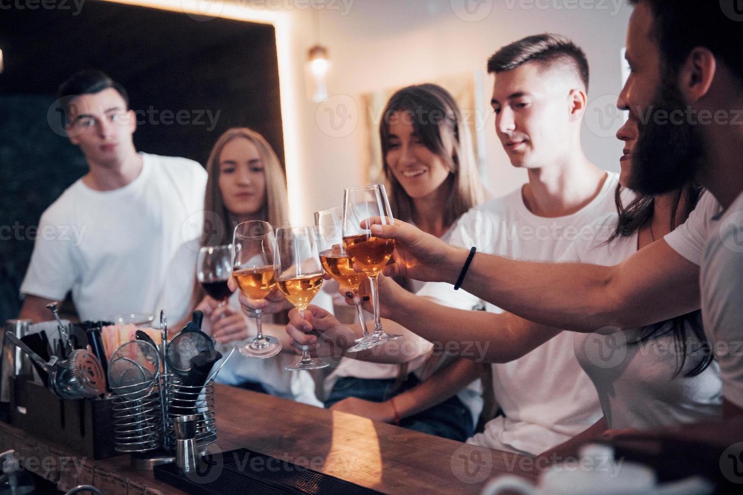 Freizeit- und Kommunikationskonzept. Gruppe glücklicher lächelnder Freunde, die Getränke genießen und sich in der Bar oder im Pub unterhalten foto