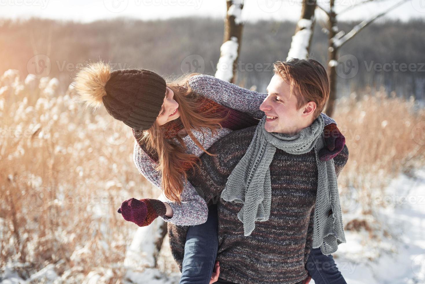 glückliches junges Paar hat Spaß auf frischem Schnee am schönen sonnigen Wintertag im Urlaub foto