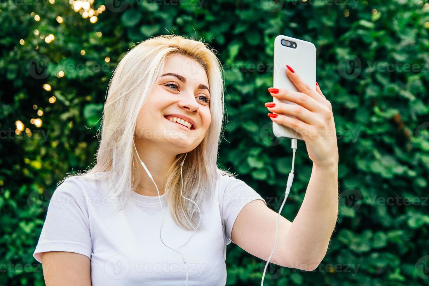 Frau mit Kopfhörern und Smartphone in den Händen foto