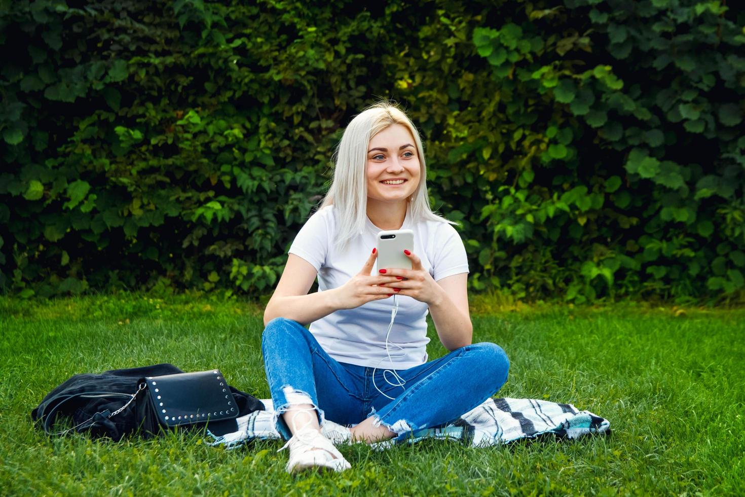 Frau mit Kopfhörern und Smartphone in den Händen foto