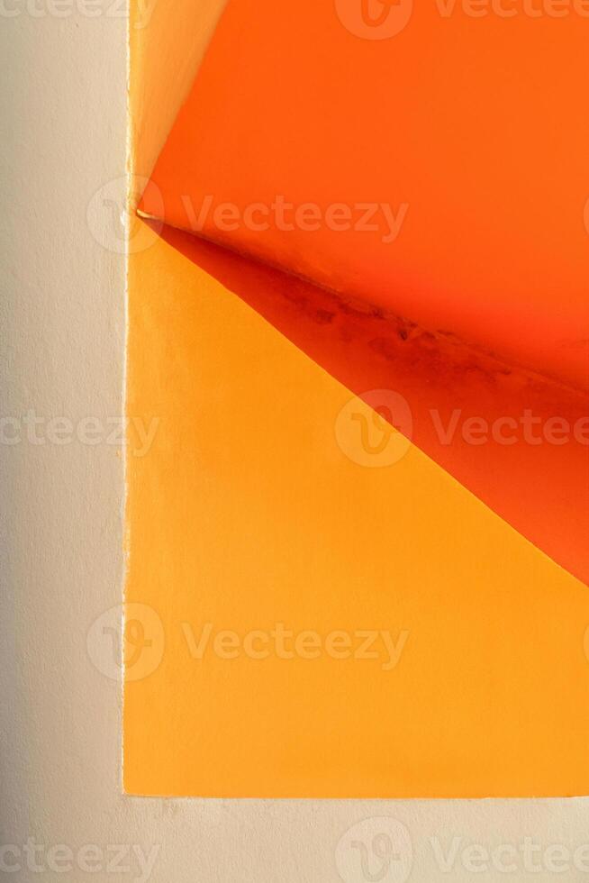 Ecke glühen, Erfassen das Schatten auf ein Orange Mauer. foto