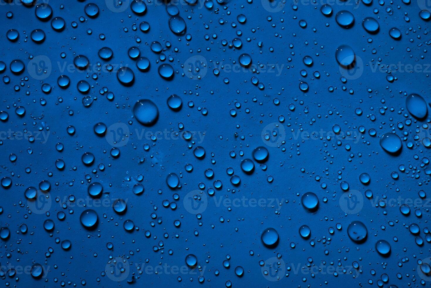 heiter Blau, schließen oben von Wasser Tröpfchen auf tief Blau Oberfläche. foto