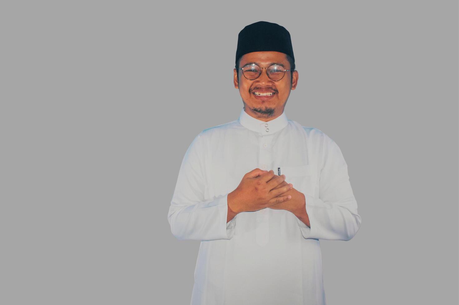 Moslem asiatisch Mann lächelnd beim das Kamera mit Hand Respekt oder Gruß Pose foto