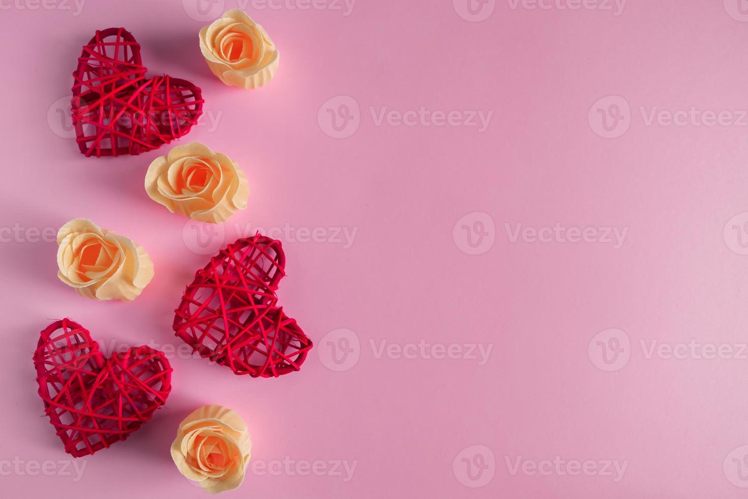 rote Herzen und Rosenknospen auf rosa Hintergrund foto