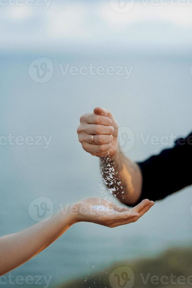 der bräutigam streut nach überlieferung solv auf die hand der braut foto