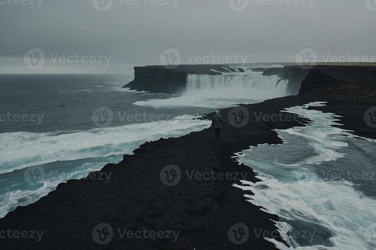 ein Mann Stehen auf das Kante von ein Cliff mit Blick auf ein Wasserfall foto