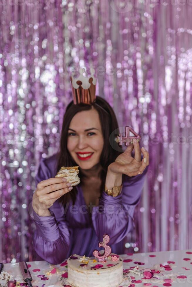 Frau feiern ihr 43 .. Geburtstag. beißt das Kuchen foto