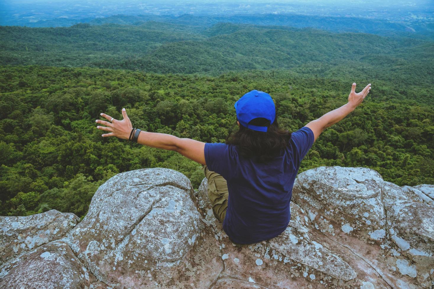 Mann Asiaten reisen im Urlaub entspannen. Blick auf die Bergnatur auf den Klippen. foto