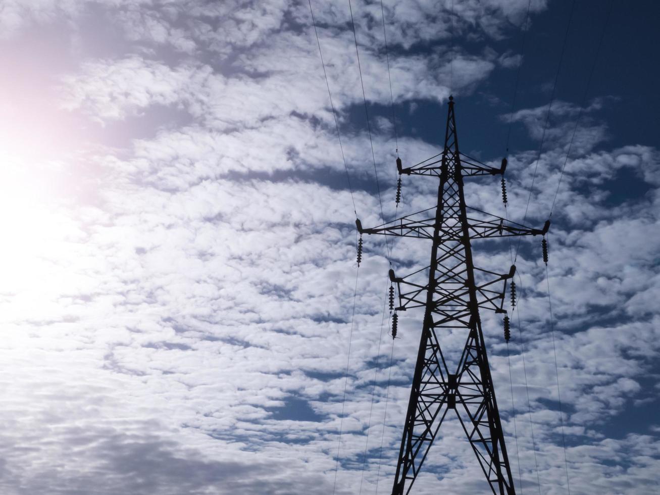 elektrischer Hochspannungsturm auf bewölktem Himmelshintergrund. foto