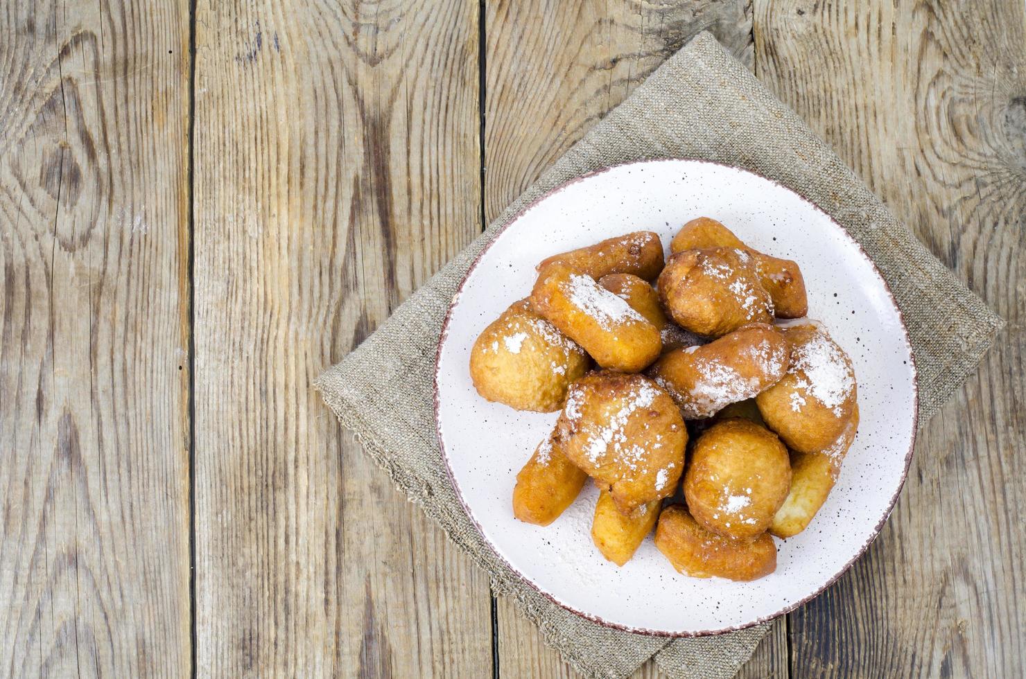 süße Quark Donuts Brötchen mit Puderzucker auf Holztisch foto