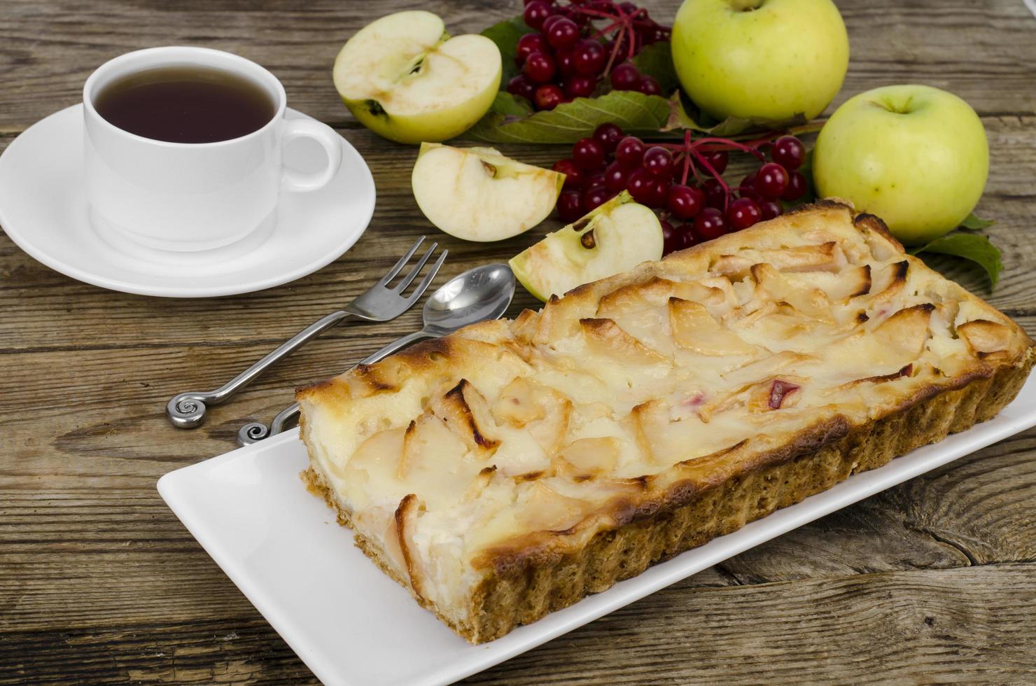 Herbstapfelkuchen mit Viburnumbeeren auf Holzuntergrund foto