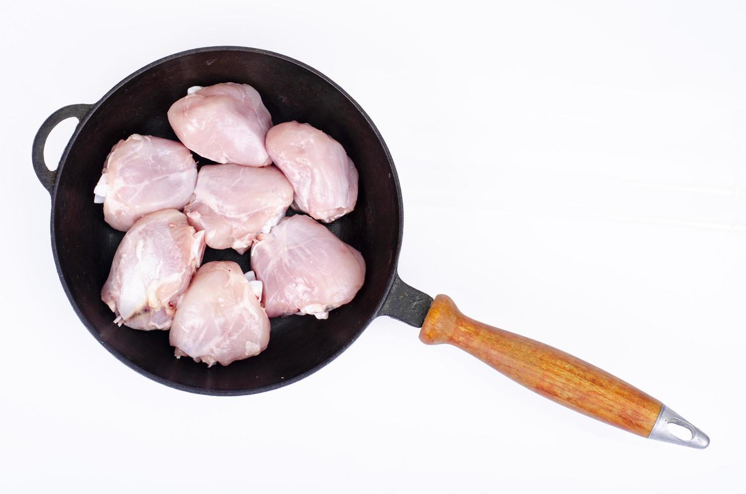 rohe Hähnchenschenkelstücke in der Pfanne zum Kochen. Studiofoto. foto