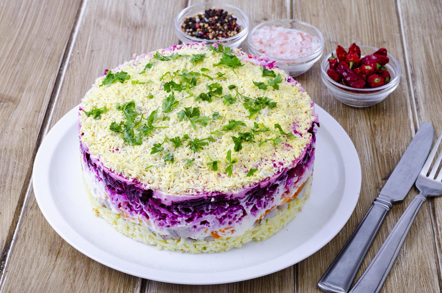 Gemüsesalat mit roter Bete und rundem Hering. Studiofoto foto