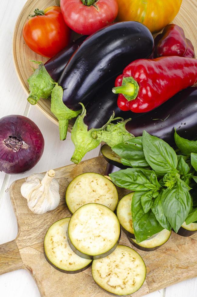 Geschnittene Auberginenscheiben auf Holzbrett, Gemüse der Saison zum Kochen. Studiofoto foto