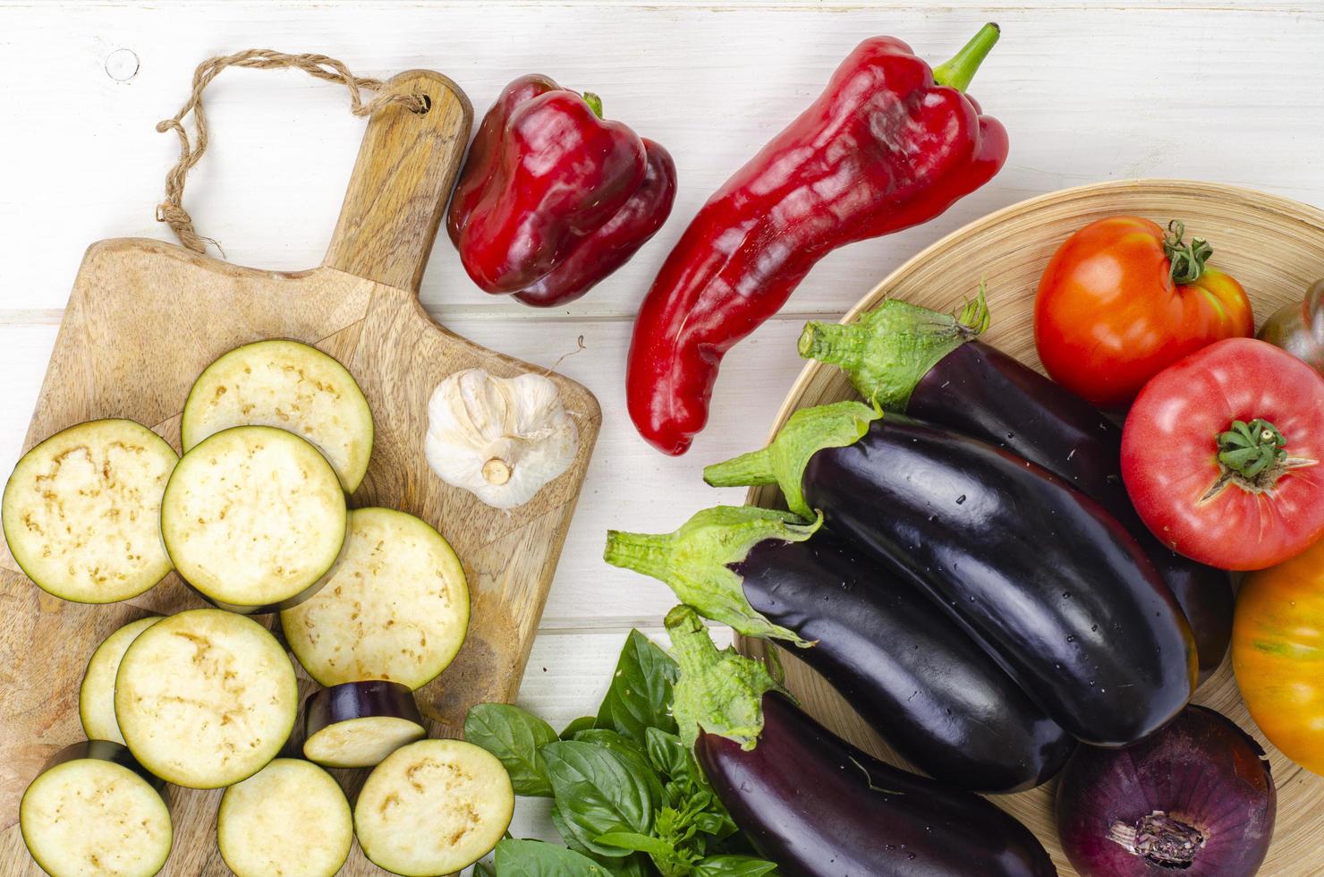 Geschnittene Auberginenscheiben auf Holzbrett, Gemüse der Saison zum Kochen. Studiofoto foto