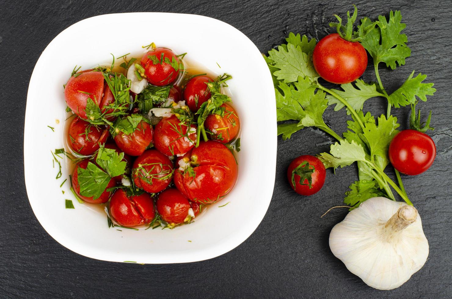 eingelegte Tomaten mit Kräutern und Knoblauch. Studiofoto. foto