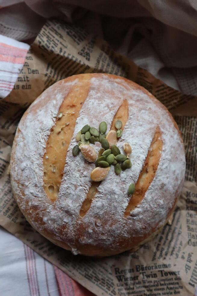 hausgemacht Sauerteig Brot frisch gebacken mit Gemüse und Grüns Dekoration foto