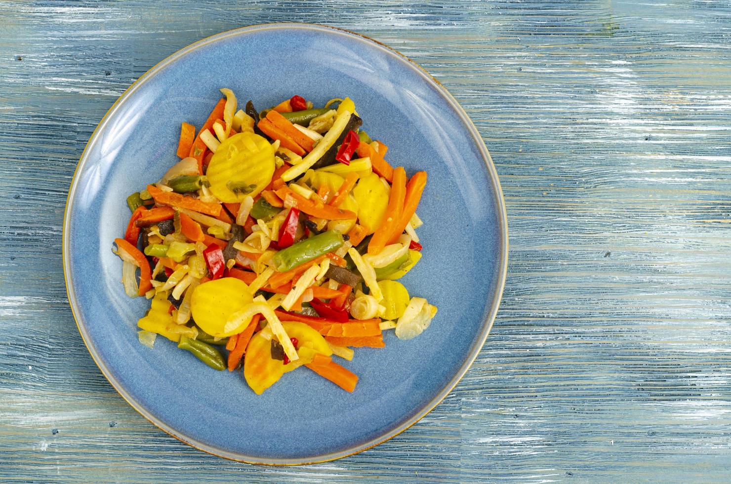Mischung aus gekochtem Gemüse in Diätkost, blauer Hintergrund. foto