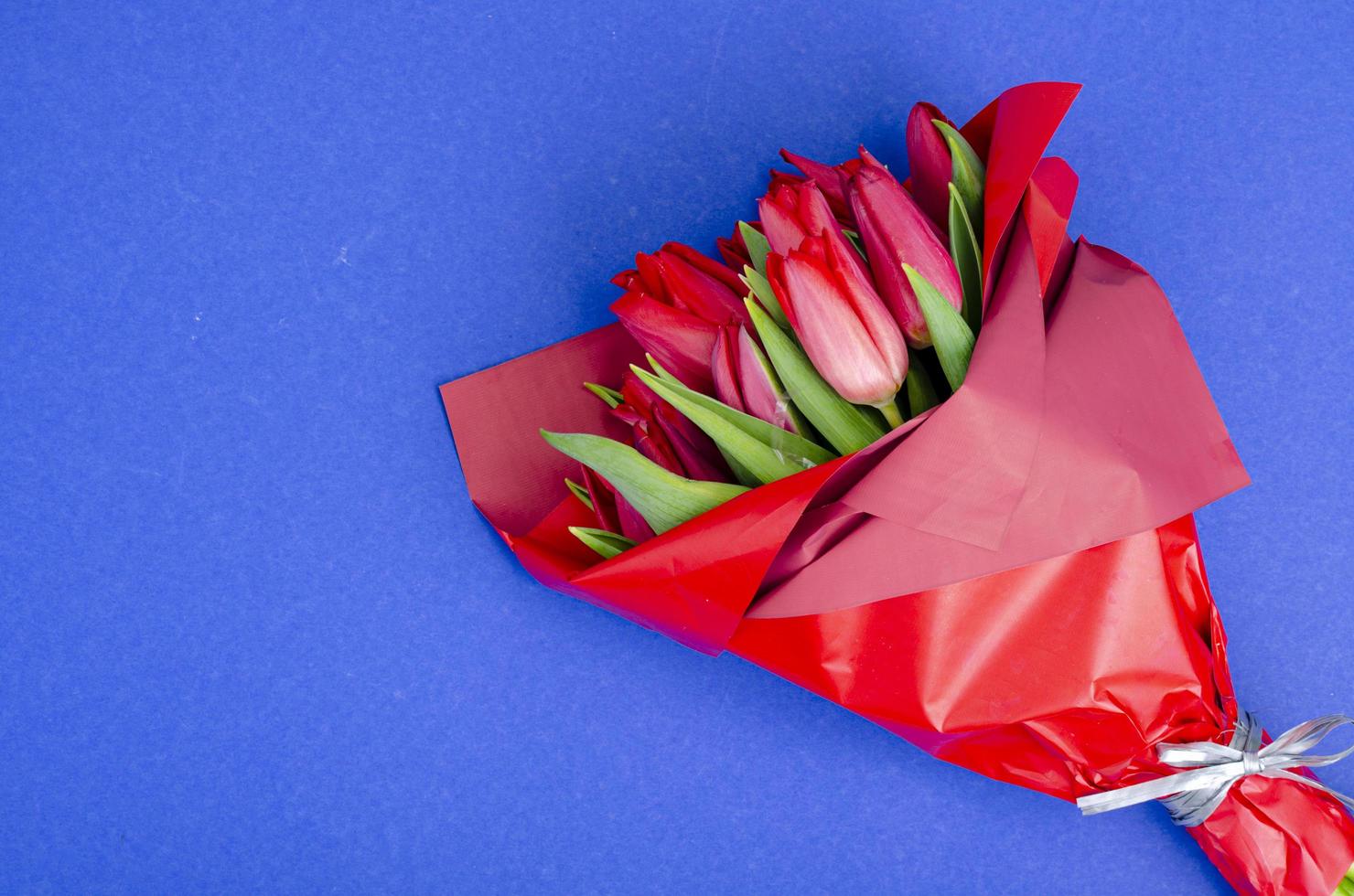 Strauß roter Tulpen in festlicher Verpackung foto