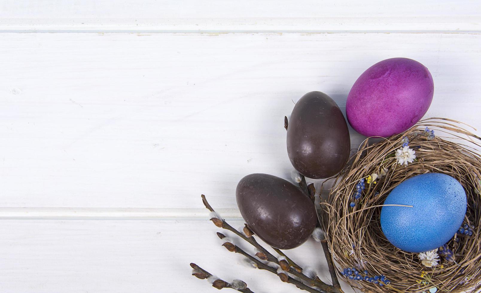 bunter Hintergrund mit Ostereiern auf weißem Holzbretthintergrund. Frohe Ostern-Konzept. kann als Poster, Hintergrund, Weihnachtskarte verwendet werden. foto