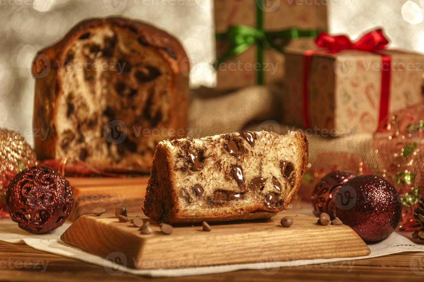 Scheibe Schokoladenpanettone auf Holzbrett mit Weihnachtsschmuck foto