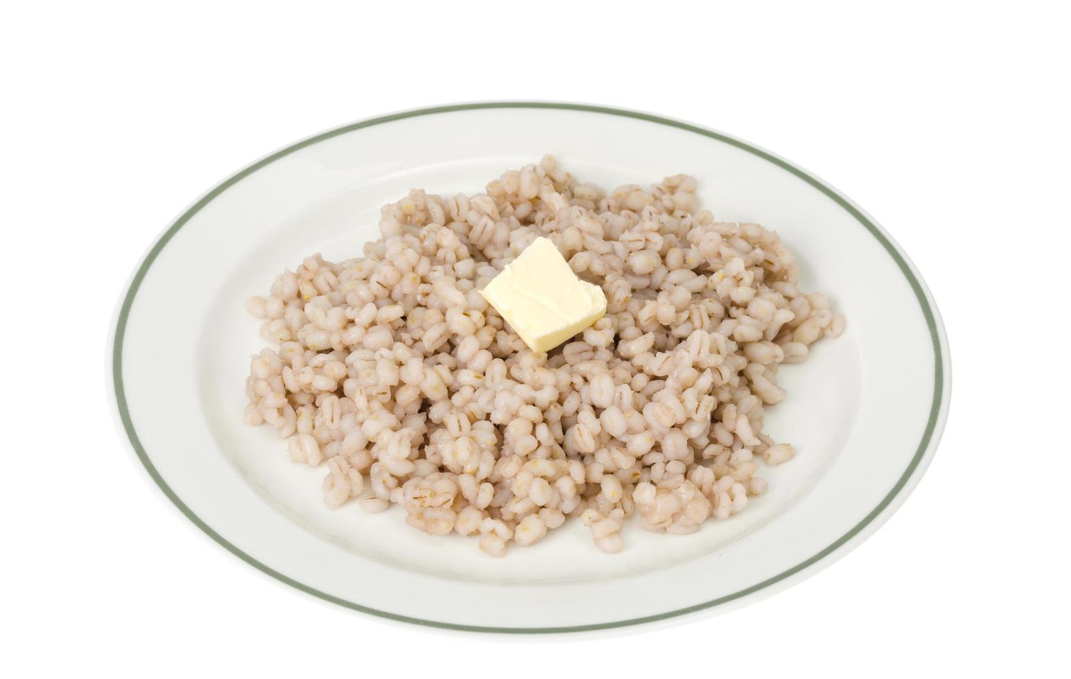 Brei, gekochte Graupen auf Teller auf weißem Hintergrund foto