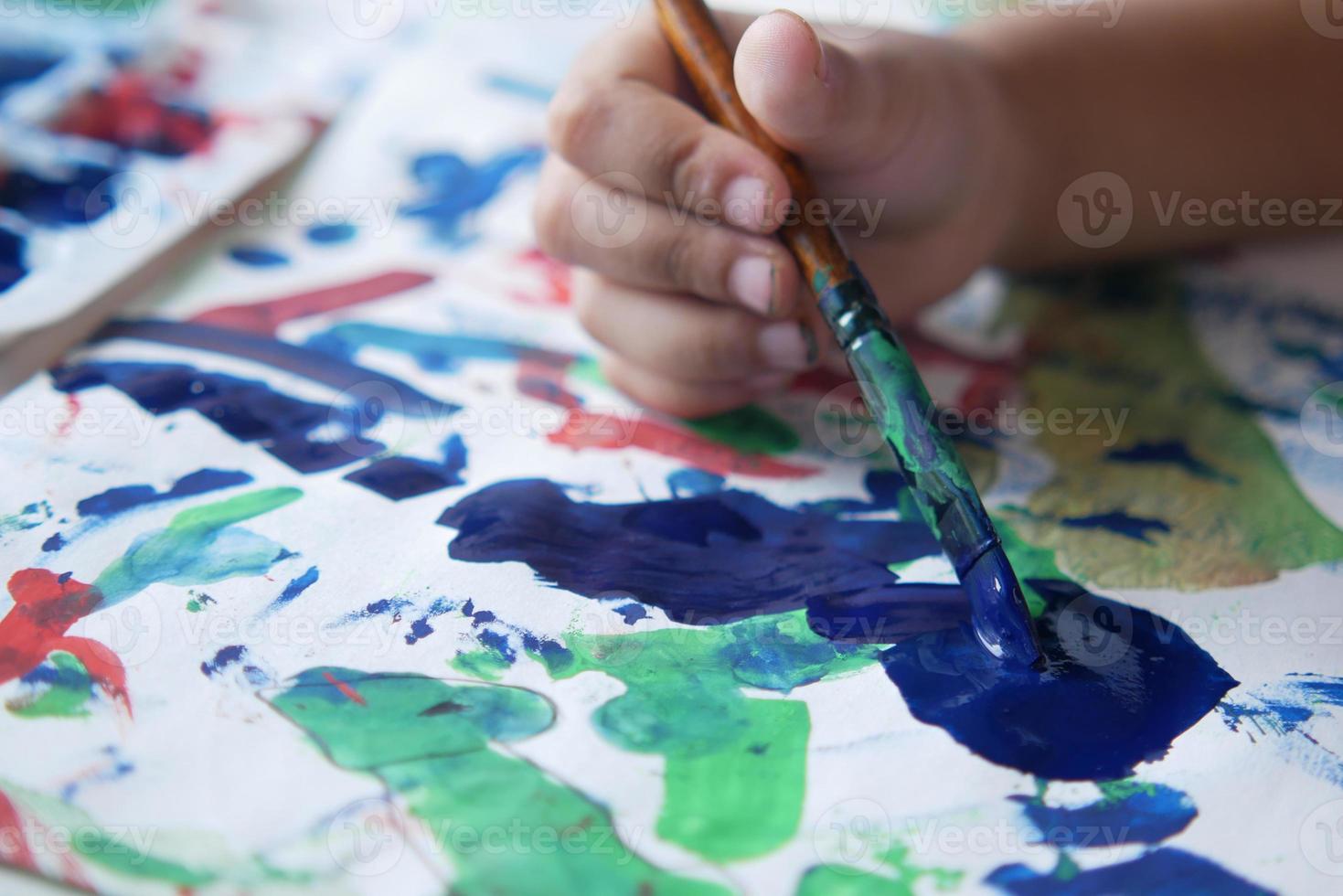 Kinderhandzeichnung mit Kunstpinsel auf Papier foto