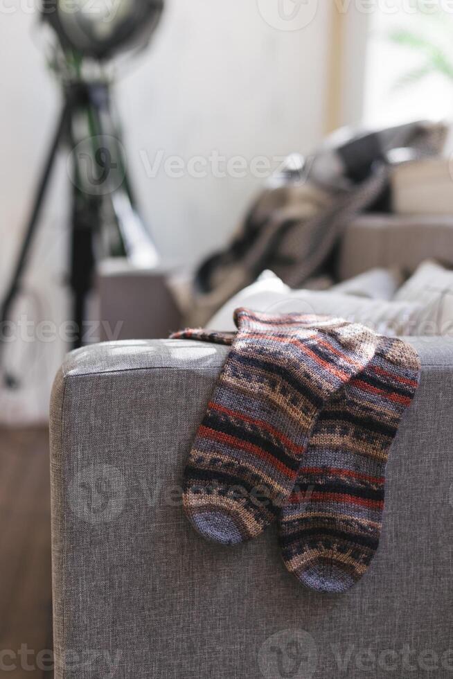 Hand gestrickt Socken auf das Sofa im modern Innere. natürlich Farben. foto