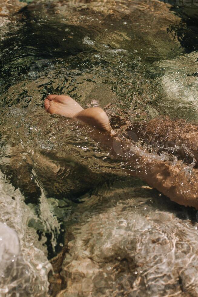 Nahansicht oben Aussicht von ein jung Frau nackt Füße im ein Wasser. foto